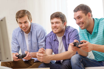 Wall Mural - smiling friends playing video games at home