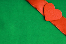 Red Wooden Decorative Heart On Green Cloth Background.