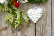 Białe serce i kwiaty na drewnianym tle