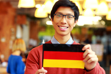 Poster - Happy asian student holding flag of germany