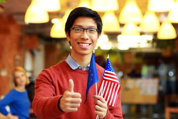 Poster - Happy asian boy in glasses holding flag of europe union 