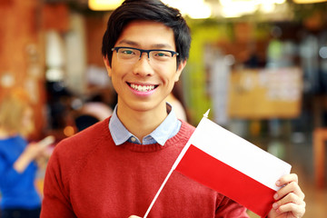 Poster - Smiling asian boy in glasses holding flag of Poland