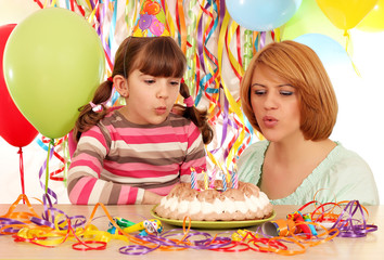 Wall Mural - Mom and daughter blowing birthday candles