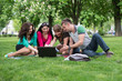 © lexmomot - Group of young student using laptop together