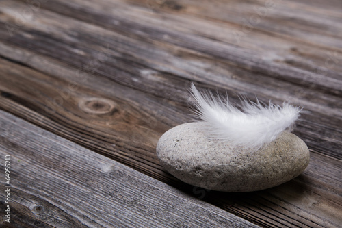 Fotografía Holz Hintergrund mit Stein und Feder als Trauer Konzept