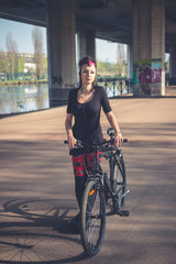 Wall Mural - young beautiful punk dark girl riding bike