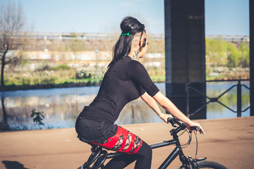 Wall Mural - young beautiful punk dark girl riding bike