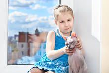 Young Girl Sitting With Cat On Window Sill