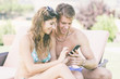 © william87 - Young Couple on Vacation using Mobile Phone