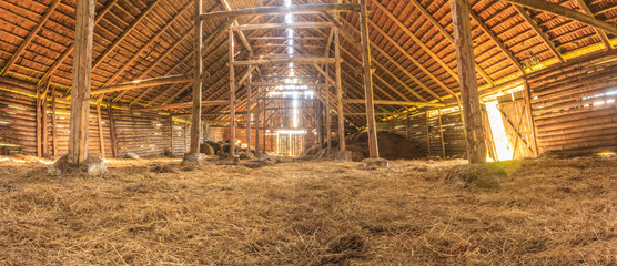 panorama interior of old farm barn with straw