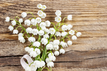 Sticker - Lily of the valley flowers on wooden background.