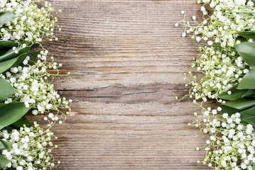 Wall Mural - Lily of the valley flowers on wooden background.