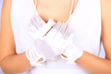 Fototapeta  - Wedding gloves on  hands of bride, close-up