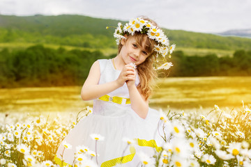 Cute child girl at camomile field