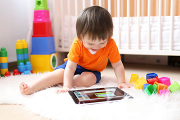 lovely baby with tablet computer at home