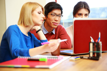 Poster - Smiling students working on laptop together