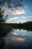 Fototapeta Natura - Summer vibrant sunset reflected in calm lake waters