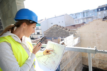 Woman engineer on building site checking construction