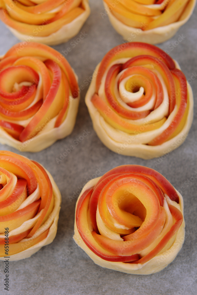 Tasty  puff pastry with apple shaped roses on pan close-up