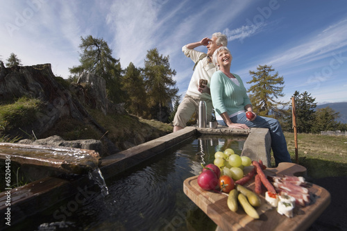 Foto Italien,Südtirol,Älteres Paar sitzt an Mulde und mit Snacks