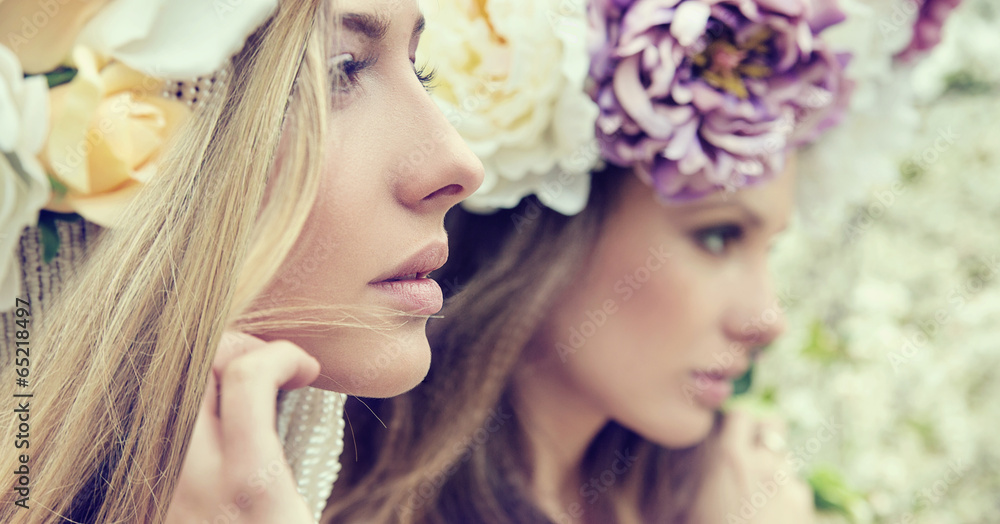 Portrait of the two gorgeous ladies with flowers - obrazy, fototapety, plakaty 