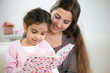 © spass - Cute little girl reading book with mother