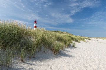 red - white lightouse on wide dune on amazing german island sylt.