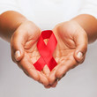 © Syda Productions - hands holding red AIDS awareness ribbon