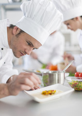 closeup on chef garnishing a plate