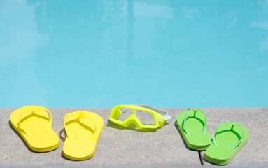 Wall Mural - Color flip flops and water glasses by the pool