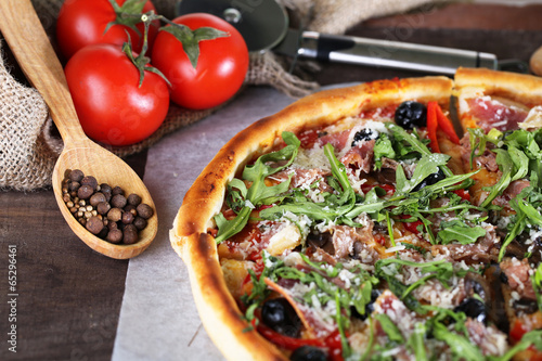 Naklejka samoprzylepna Pizza z rukolą na kolor drewniane tła