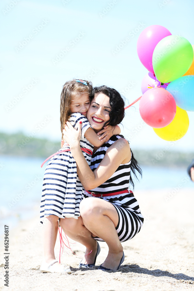 Happy mom and daughter on the beach