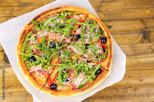 Naklejka samoprzylepna Pizza z rukolą na kolor drewniane tła