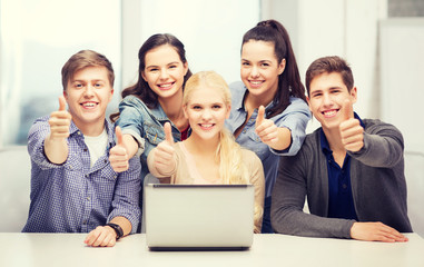 Wall Mural - smiling students with laptop showing thumbs up