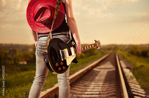 Obraz w ramie woman with guitar at railway road