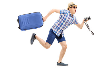 Wall Mural - Male tourist rushing with his baggage and camera