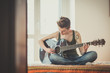 © Eugenio Marongiu - young lesbian stylish hair style woman playing guitar