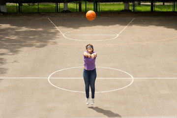 Wall Mural - Young girl shooting a basketball