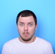 © irishmaster - Portrait of man with dusgusted gesture against blue background