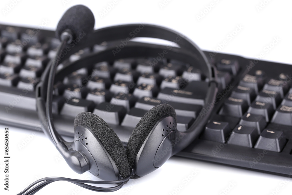 Headphone and keyboard, close-up, isolated on white
