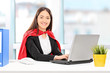 Female superhero working on laptop in an office