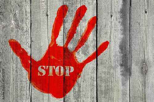 Naklejka na drzwi Handprint with the word ''Stop'' on old wooden fence background