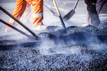 Workers Making Asphalt With Shovels At Road Constructio