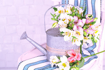 Poster - Beautiful bouquet of freesias in watering can on chair in room