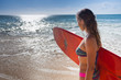surfer girl with surfboard near the ocean
