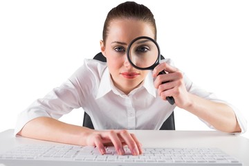 Aufkleber - Businesswoman typing and looking through magnifying glass