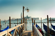 Venice gondolas pier with blue gondola on a Grand channel