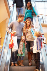 Family On Escalator In Shopping Mall Together