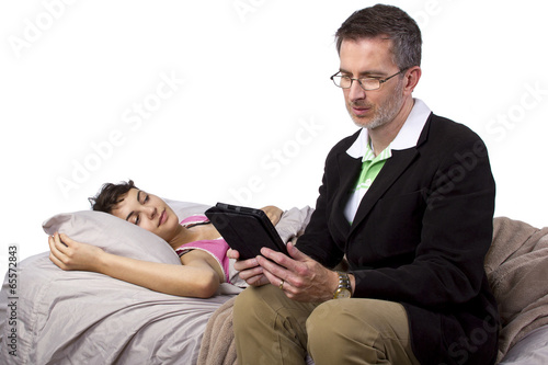 Fotografie, Obraz young dad tutoring sick daughter laying in bed