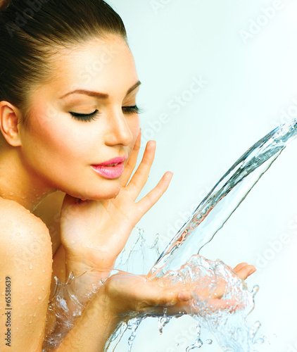 Naklejka dekoracyjna Beautiful woman with splashes of water in her hands